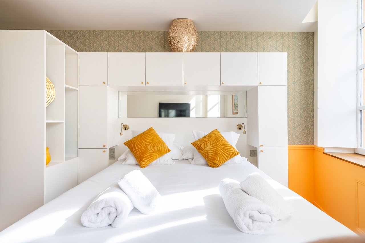 Chambre Deluxe : lit face aux boiseries blanches